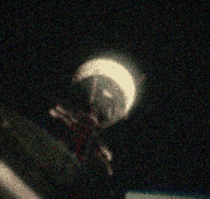 An astronaut's helmet lit against black space, seen from a spacecraft window